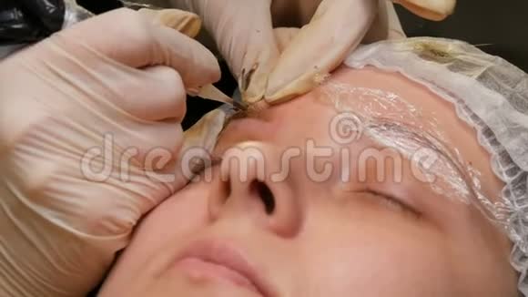 麻醉下的一个眉毛在第二位大师上美容师用颜料给眉毛上色眉毛视频的预览图