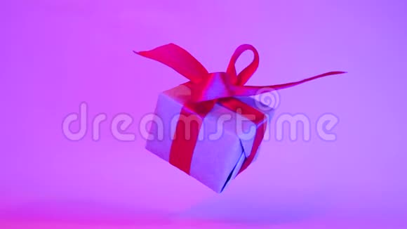 礼品盒红色丝带旋转霓虹灯紫色背景360度旋转无缝环零度视频的预览图