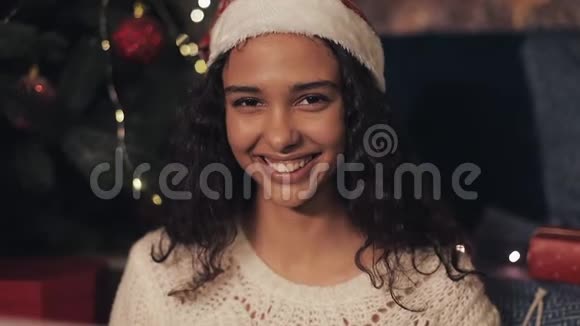 特写穆拉托年轻美丽的女孩的肖像看着快乐微笑着坐在相机坐在舒适的圣诞节视频的预览图
