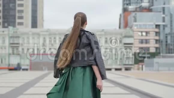 美丽漂亮的姑娘穿着漂亮的晚礼服欢快而快乐地走在靠近的空城广场上视频的预览图