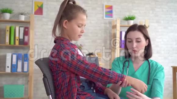 医生检查了一名坐轮椅的少女受伤后的手视频的预览图