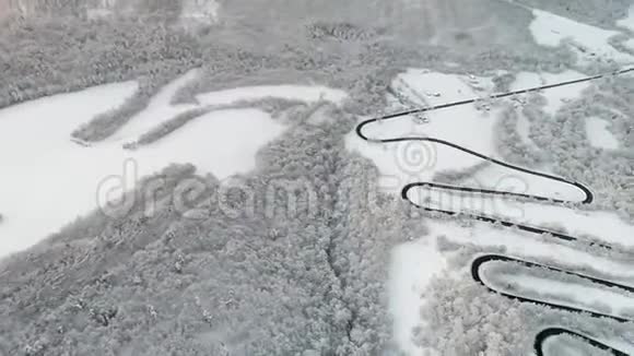 旋转的空中拍摄在一个令人惊叹的冬季景观蜿蜒的道路视频的预览图