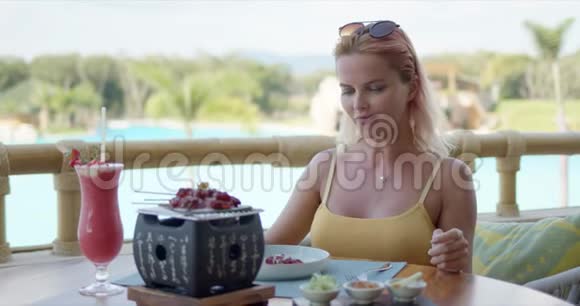 可爱的女人在咖啡馆露台上吃饭视频的预览图