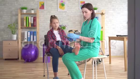 物理治疗师告诉一个有矫形问题的少女有关平脚矫正的矫形鞋垫视频的预览图