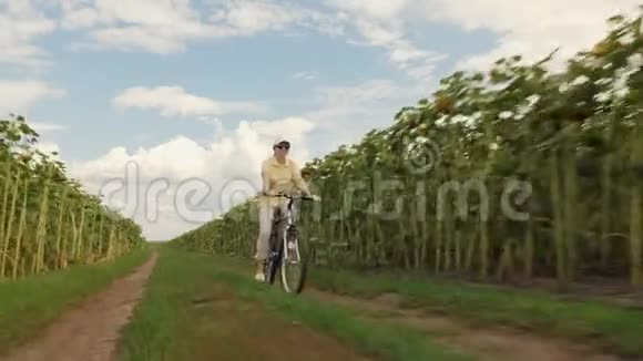 快乐的女人在乡间小路上骑自行车视频的预览图