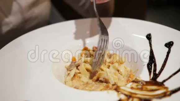 大盘子里的意大利面的特写女人用叉子的手视频的预览图