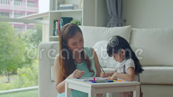 快乐的年轻母亲在纸上画女儿视频的预览图