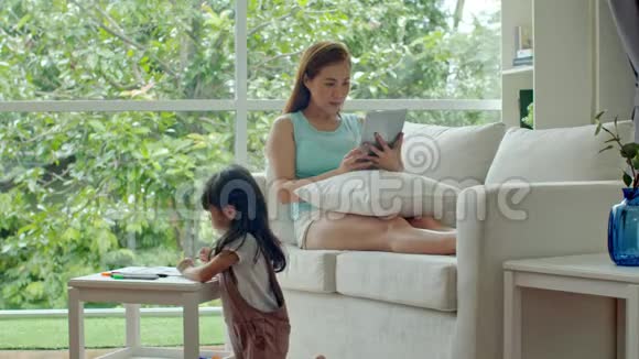 年轻的妈妈和平板电脑聊天女儿在画纸视频的预览图