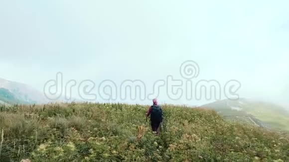 年轻女子背着背包走向山顶慢动作女士在美丽的白种人山区徒步旅行阿代盖视频的预览图
