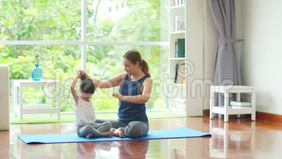 年轻的母亲正在为女儿教授基本的瑜伽姿势视频的预览图