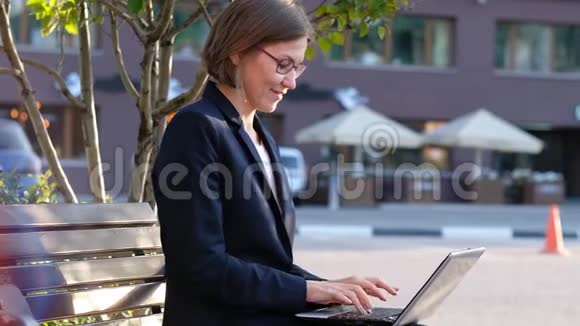 年轻的商务女性带着笔记本电脑庆祝表达快乐和成功视频的预览图