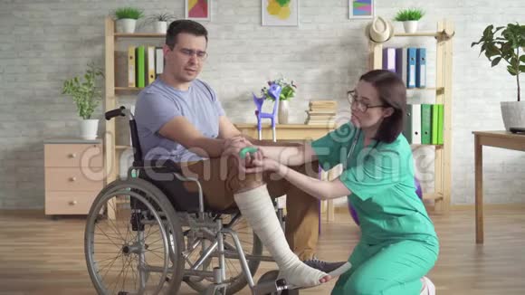 物理治疗师在受伤后帮助轮椅上的人用扩腕器做运动视频的预览图