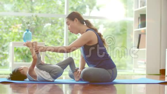 年轻的母亲教她可爱的女儿做基础瑜伽视频的预览图
