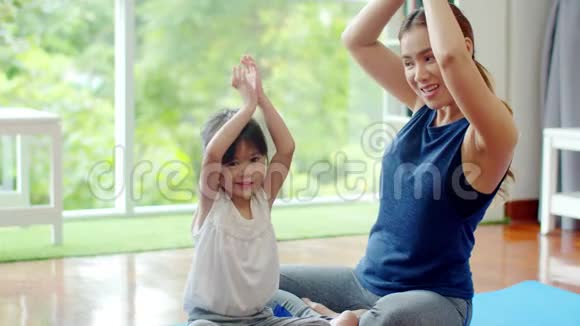 小女儿试图和年轻的母亲一起学习瑜伽视频的预览图