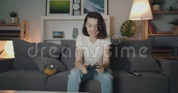 漂亮的女士晚上在家玩电子游戏然后拍手视频的预览图