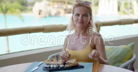微笑的女性在度假酒店的咖啡馆吃饭视频的预览图