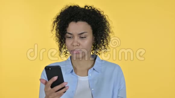 令人沮丧的非洲女性在智能手机上生气的肖像视频的预览图