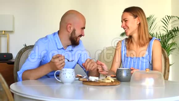 快乐的一对在家吃早餐快乐的女人在私人厨房亲吻男人视频的预览图
