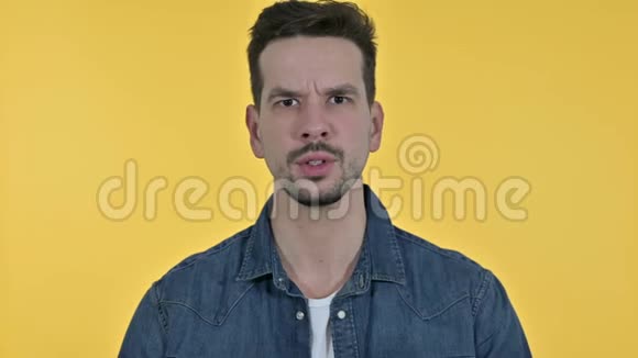 失望的年轻人愤怒的肖像黄色背景视频的预览图