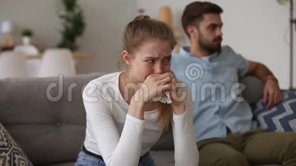 夫妻吵架坐在沙发上专注于哭泣的女孩视频的预览图