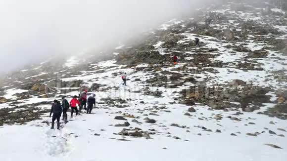 一群登山者在冬天从山上下来多云视频的预览图