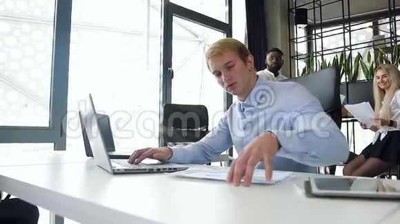 英俊的年轻金发商人漂亮的肖像用笔记本电脑上的图表分析报告视频的预览图