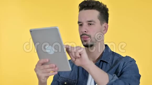 勤劳的年轻人用平板电脑的肖像黄色背景视频的预览图