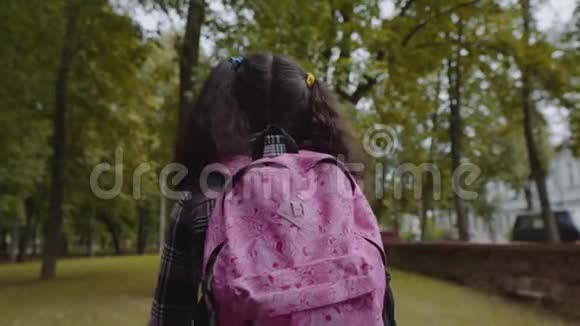 在公园散步的女学生的后景回到学校的概念慢动作镜头视频的预览图