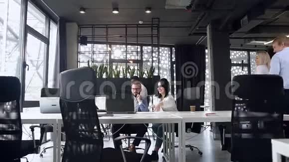两个男人和女人在现代办公室给他们的商业伙伴五个的漂亮照片视频的预览图