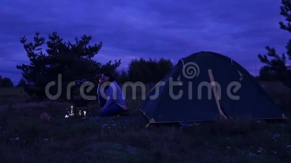 晚上一男一女在帐篷里篝火炸肉视频的预览图