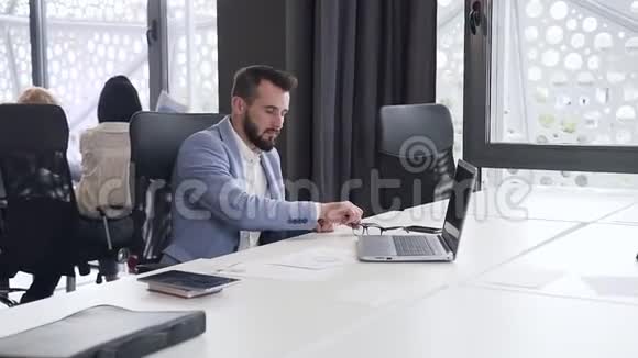 体贴英俊的办公室经理戴着眼镜在电脑上工作不同的报告都有图表视频的预览图