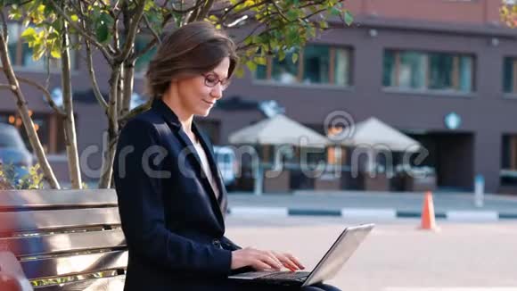 年轻的商务女性带着笔记本电脑庆祝表达快乐和成功视频的预览图