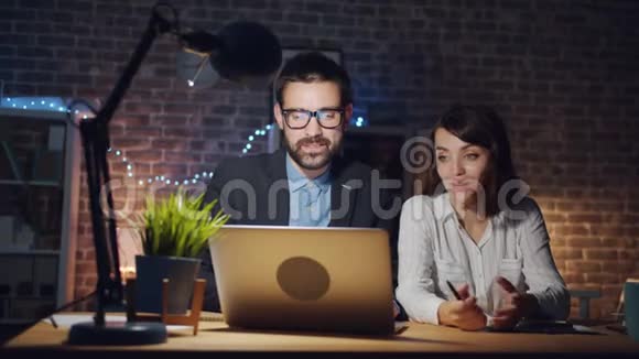 男女同事在办公室用手提电脑谈话的画像视频的预览图