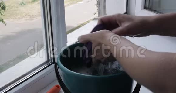 年轻女士正在用清洁剂擦窗户视频的预览图