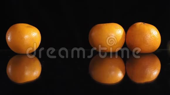 黑色背景下的一排柑橘类水果玻璃表面的反射视频的预览图