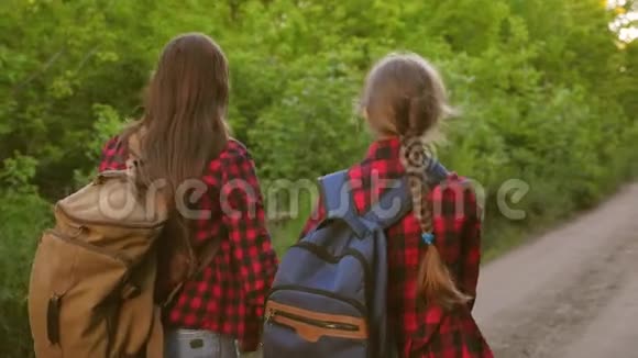 十几岁的女孩手牵着背包旅行游客儿童沿着乡村道路走快乐的家庭旅行视频的预览图