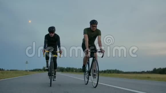 两个骑自行车的人在路上互相赛跑视频的预览图
