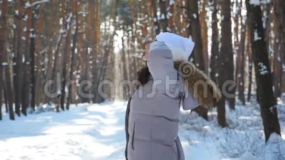 年轻的黑发女人在雪地森林里漫步迷人的女人旋转享受美丽的冬日免费女士视频的预览图