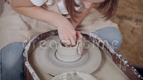 女人在花盆的轮子上塑造花瓶视频的预览图