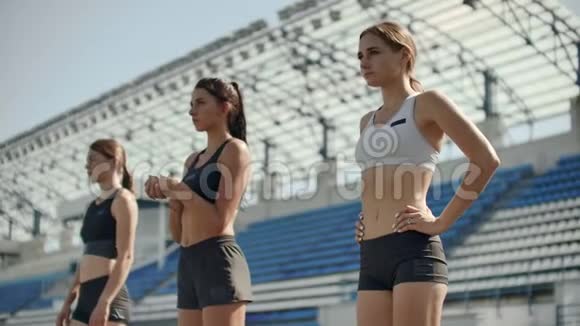 一组女运动员在跑步跑道上开始冲刺的侧视跑步者从起点起飞视频的预览图
