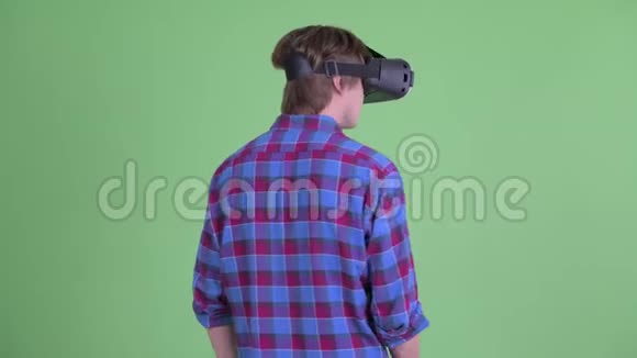 使用虚拟现实耳机的年轻潮男的后视图视频的预览图