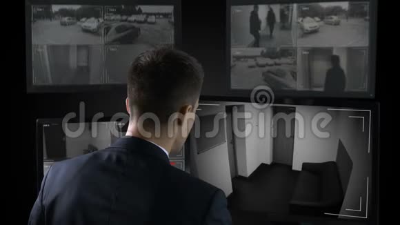 保安在闭路电视前观看银行抢劫案报警视频的预览图