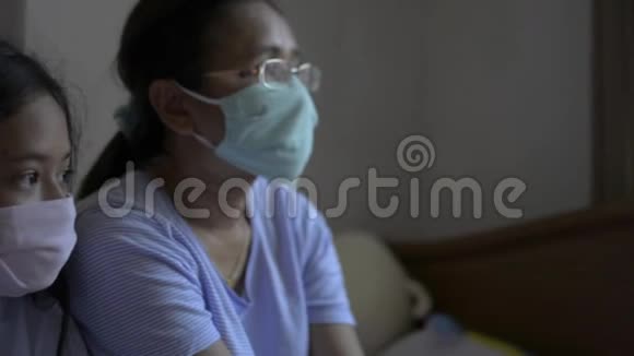 母亲和女儿戴着防护面罩以保护自己免受电晕病毒的影响并呆在家里视频的预览图