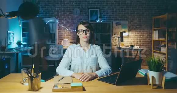 在办公室办公桌前工作的漂亮女人的变焦延时画像视频的预览图