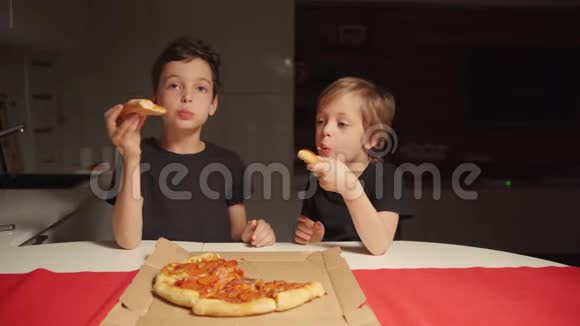两个男孩深夜在家厨房吃披萨一个人在家视频的预览图