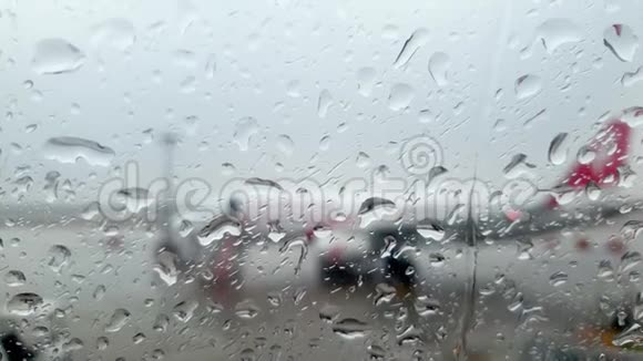 在暴雨期间通过机场候机楼和飞机的湿机窗特写4k视频视频的预览图