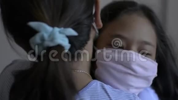 母亲和女儿拥抱在一起戴着防护面具在COVIC19疫情期间视频的预览图