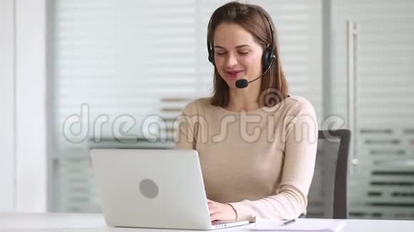 微笑商务女性接待员戴耳机咨询在线客户视频的预览图