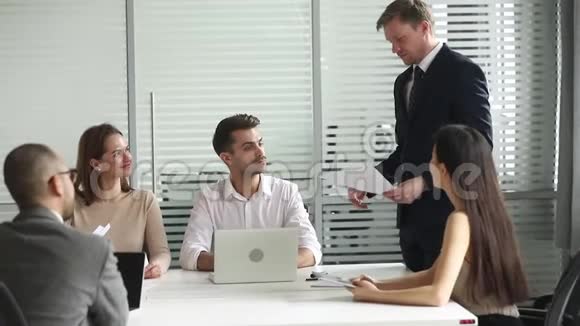 男性经理提交书面报告向员工提供业务计划视频的预览图