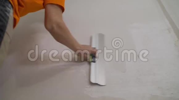 施工工人用长铲抹灰一面墙混凝土的特写工人用灰浆在白色的墙上堵住裂缝视频的预览图